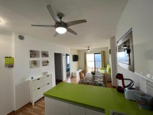een keuken met een groen aanrecht en een woonkamer bij Teneryfa -apartament z cudownym widokiem na ocean. in Puerto de Santiago