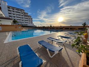 basen z niebieskimi krzesłami i hotel w obiekcie Teneryfa -apartament z cudownym widokiem na ocean. w mieście Puerto de Santiago