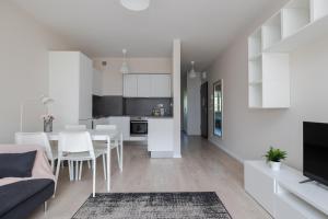 a white apartment with a dining room and a kitchen at ShortStayPoland Pohulanka (B85) in Warsaw