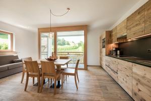 cocina y comedor con mesa y sillas en Natur Suite Edelweisshof App Heidi, en Chiusa