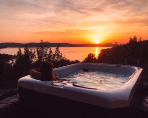 una mujer sentada en una bañera con la puesta de sol en Infinity, en Šibenik