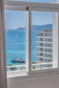 una ventana con vistas al océano y a un edificio en Suncoast Ibiza Hotel - Adults Only - en Ibiza