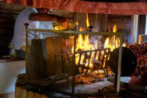 a man is cooking food in an oven at Agriturismo Le Noci in Tarzo