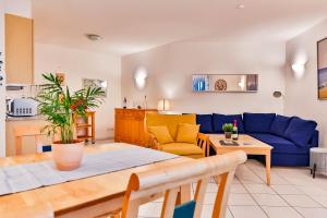uma sala de estar com um sofá azul e uma mesa em Apartment Ostseerose ein Strandkorb ist im Sommer inclusive em Zempin