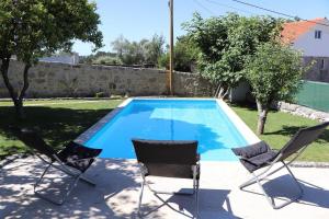 2 sillas y una piscina en un patio en Casa do Mestre Inteira, en Vila de Punhe