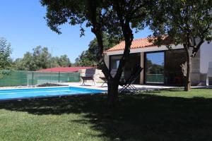 una casa con un árbol junto a una piscina en Casa do Mestre Inteira, en Vila de Punhe