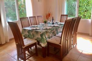 einen Esstisch mit Stühlen und eine Tischdecke mit einem Tisch und einem Chairsktop in der Unterkunft Villa Alcudia Beach by Villa Plus in Port d'Alcúdia