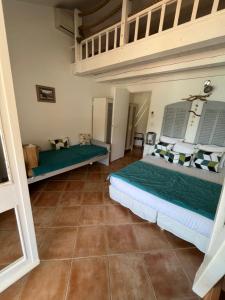 Habitación con 2 camas y suelo de baldosa. en Hostellerie Provencale, en Port-Cros