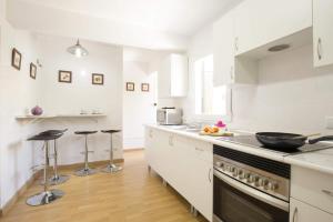 een keuken met witte kasten en een fornuis met oven bij Villa Oleanda by Villa Plus in Port d'Alcudia