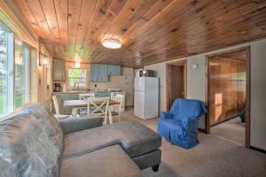 a living room with a couch and a kitchen at Cozy Cabin with Deck and Private Dock on Nelson Lake! in Hayward