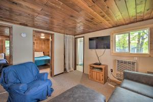 a living room with a couch and a tv at Cozy Cabin with Deck and Private Dock on Nelson Lake! in Hayward