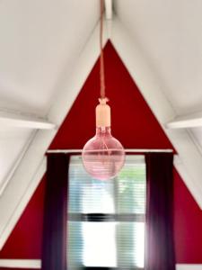 een hanglamp in een kamer met een raam bij A- Frame huisje Ardennen in Durbuy +44 foto's