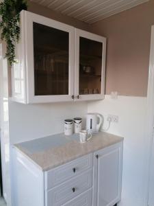 cocina con armarios blancos y encimera en Beautiful three bedroom seaside retreat, en Prestonpans