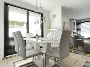 a white dining room with a white table and chairs at Ferienhaus Schwan in Neu Pastitz