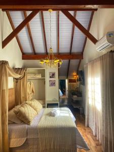 um quarto com uma cama e um lustre em Pousada La Lavande em Gramado
