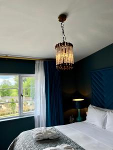 a bedroom with a bed and a chandelier at Magmell Townhouse in Wicklow