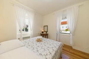 een witte slaapkamer met een bed en twee ramen bij Holiday Home Lavanda in Iž Mali +40 foto's