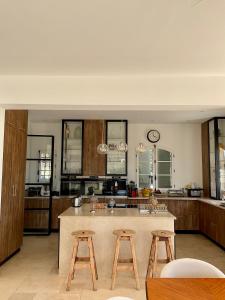 a kitchen with wooden cabinets and a large island with stools at La Soleillade Aixoise in Aix-en-Provence