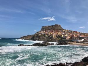 une ville au sommet d'une colline près de l'océan dans l'établissement Domus Rubra, à Castelsardo