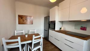 a kitchen with a wooden table and white cabinets at Apartment Carina 2 in Koper