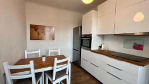 eine Küche mit einem Holztisch und weißen Schränken in der Unterkunft Apartment Carina 2 in Koper