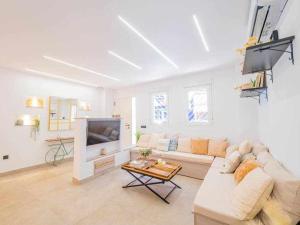 een witte woonkamer met een bank en een tv bij Casa Moises By Solymar Holiday in Torre del Mar