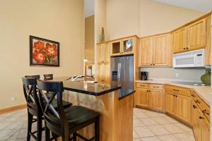a kitchen with wooden cabinets and a black refrigerator at Interlachen Unit 18 in Nisswa