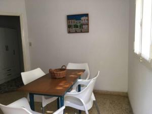 a dining room table with white chairs and a basket on it at DEPTO PAZ in Dolores
