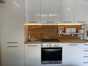 uma cozinha com armários brancos e um lavatório em La Room: seaside apartment + terrace + parking em Menton