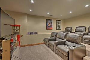 a theater room with leather chairs and a flat screen tv at Golf, Ski and Hike Luxe Group Getaway in Granby! in Granby