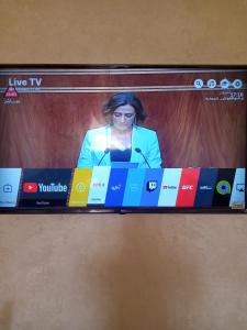 una pantalla de televisión con una mujer hablando en un micrófono en salwa, en Ifrane