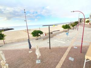 a empty street with a beach and a street light at Vista Mar in Puerto del Rosario