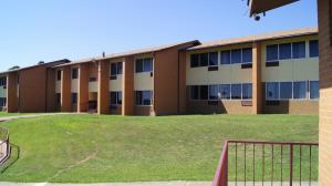 un edificio escolar con un patio de césped delante de él en Holiday Lodge & Suites en McAlester