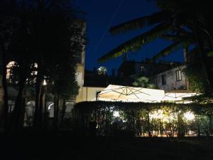 un gruppo di ombrelli sono illuminati di notte di Corte Meraviglia - Relais a Lucca