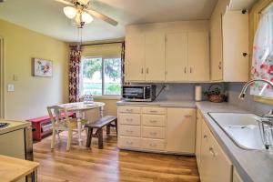 a kitchen with white cabinets and a table and a dining room at Idaho Falls Farmhouse about 11 Mi to Downtown! in Idaho Falls