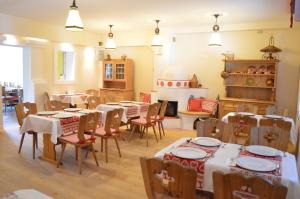 a dining room with tables and chairs and a kitchen at Hotel Aquamarin in Bad Mitterndorf