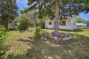 a house with a tree in the yard at Idaho Falls Farmhouse about 11 Mi to Downtown! in Idaho Falls