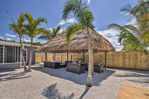 d'une terrasse avec un parasol et des palmiers. dans l'établissement Palm City Canalfront Home with Tiki Hut and Dock!, à Palm City