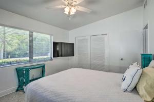 - une chambre avec un lit et un ventilateur de plafond dans l'établissement Palm City Canalfront Home with Tiki Hut and Dock!, à Palm City