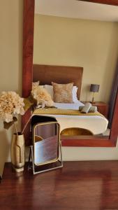 Homely Apartment, Hatfield, Unit-9 في بريتوريا: غرفة نوم مع سرير مع مرآة بجوار مرآة