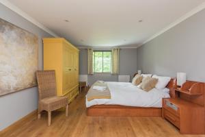 ein Schlafzimmer mit einem Bett, einem Schreibtisch und einem Stuhl in der Unterkunft Poundgate Park Cottage in Crowborough