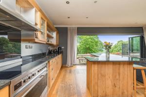 eine Küche mit einer Theke und einem großen Fenster in der Unterkunft Poundgate Park Cottage in Crowborough