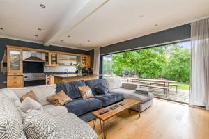 ein Wohnzimmer mit Sofa und Tisch in der Unterkunft Poundgate Park Cottage in Crowborough