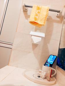 a bathroom with a cell phone sitting on a toilet at Bapaq Mahkota Apartment Melaka in Malacca