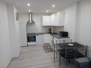 a kitchen with white cabinets and a table in it at Appartement Standing Cœur d'Annecy in Annecy