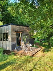a small cabin with a table and chairs on a deck at Ecolodge La Belle Verte in Saint-Mʼhervé