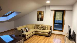 a living room with a couch and a window at Atico Plus A Valenzá in Ourense