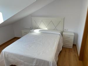 a bedroom with a white bed with a white blanket at Atico Plus A Valenzá in Ourense