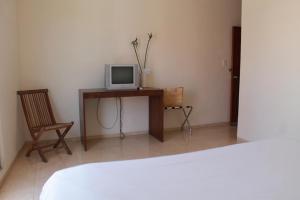 a room with a bed and a desk with a television at Cabanas Maria Del Mar in Isla Mujeres
