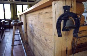a bell on the side of a wooden wall with a stool at Hotel Aquamarin in Bad Mitterndorf